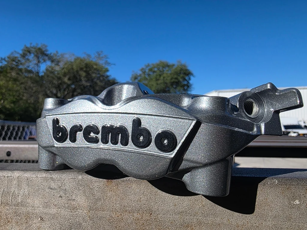 Close view of a textured silver Brembo brake caliper